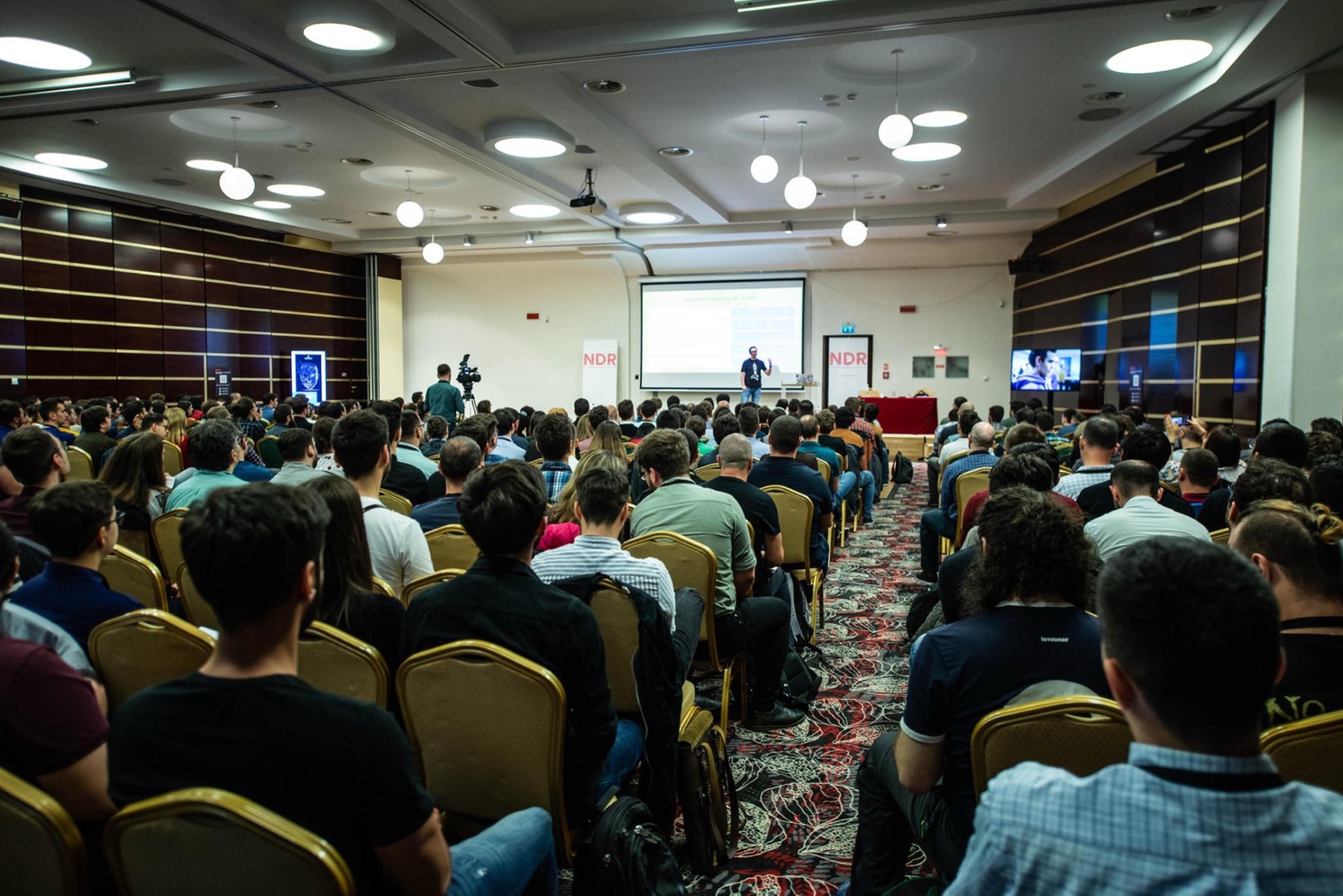 A large conference audience watching Henk speak